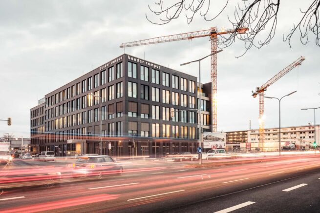 Bender Campus mit Baustelle in der Morgendämmerung, Langzeitbelichtung mit LIchtlinien des Verkehrs.